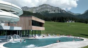 库尔瓦尔登Alpine Cocoon的一座带游泳池的度假村,里面的人