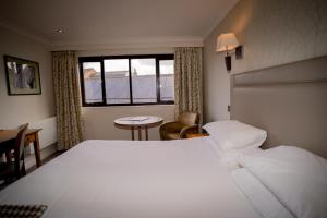 温彻斯特Winchester Royal Hotel的一间设有大床和窗户的酒店客房