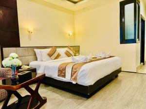 甘托克Tara Palace Resort and SPA的一间卧室配有一张大床和一张桌子