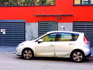 米兰L' appartamento sul Naviglio的停在红色建筑前面的白色汽车
