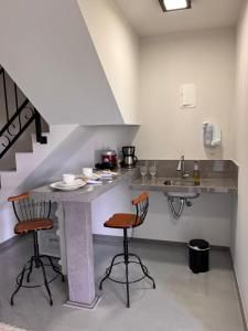新文达移民镇Chalé Bella Vista的厨房配有桌子、两把椅子和水槽