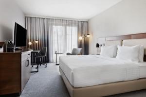 慕尼黑慕尼黑东部万豪酒店的酒店客房设有一张大床和一张书桌。