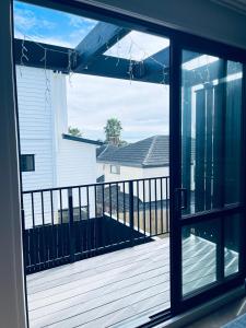 奥克兰Stylish Industrial Holiday House in Pakuranga Free Wifi Netflix的从带甲板的门廊的窗户欣赏美景