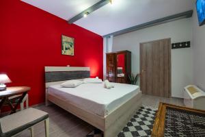 塞尼梅西奇卡罗Ξενώνας Ηχώ的卧室设有红色墙壁、一张床和一张桌子