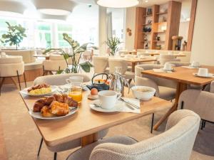 特鲁瓦特鲁瓦中心美居酒店的餐厅的餐桌上摆着早餐食品