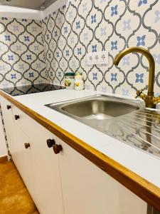 丰东Apartamentos rurales, La Casa de Baltasar的厨房配有水槽以及蓝色和白色的瓷砖