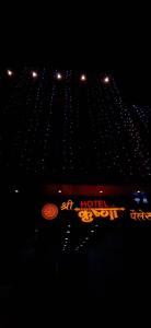 乌贾因Hotel Shri Krishna Palace的夜间在大楼前的酒店标志