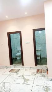 乌贾因Hotel Shri Krishna Palace的浴室设有两面镜子、盥洗盆和卫生间