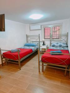 卡塔尼亚Capuana House的一间位于地面楼层的客房内的两张单人床