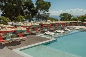 马盖鲁夫Dreams Calvia Mallorca的毗邻度假酒店的带躺椅和遮阳伞的游泳池
