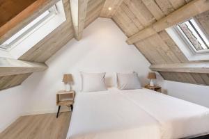 奥德多普Huisje Bries, Nieuw! mooi uitzicht, vlakbij strand的卧室配有白色的床和2扇窗户。