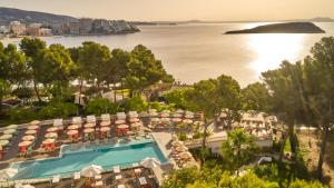 马盖鲁夫Dreams Calvia Mallorca的享有带游泳池和遮阳伞的度假村的空中景致