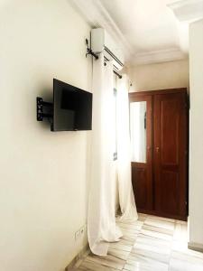 达喀尔Studio Moderne Dakar Keur Ndiaye LÔ的一间设有电视和门的墙壁的房间