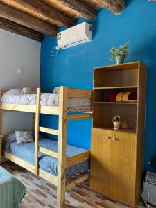 Las HerasMonoambiente lo de Carola Mendoza的一间卧室设有双层床和蓝色的墙壁