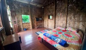 斯里曼加尔乌帕齐拉Oronner Din Ratri的木制客房内的一间卧室,配有一张床