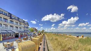 蒂门多弗施特兰德Mein Strandhaus - Hotel, Restaurant & Schwimmbad的海滩旁的一排桌椅