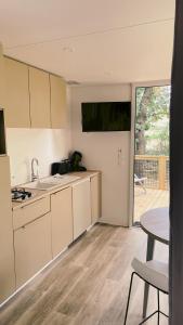 孔格林Camping Sunelia L'Argentière的厨房配有白色橱柜、桌子和用餐室。