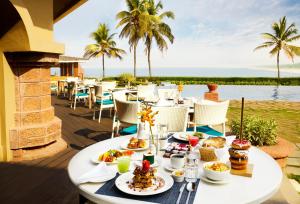 坎多林果阿泰姬堡阿瓜达度假酒店的露台的桌子,有食物,有海洋背景