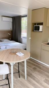 孔格林Camping Sunelia L'Argentière的配有床和桌子的房间以及厨房