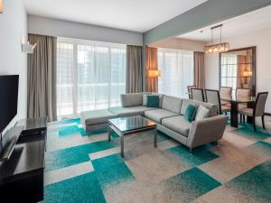 迪拜Flora Creek Deluxe Hotel Apartments, Dubai的客厅配有沙发和桌子