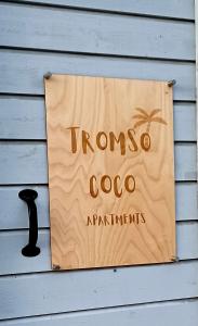 特罗姆瑟Tromso Coco Apartments in Center的棕榈树屋边的标志