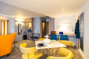 梅赫伦梅赫伦中心诺富特酒店的客厅配有桌子和黄色椅子