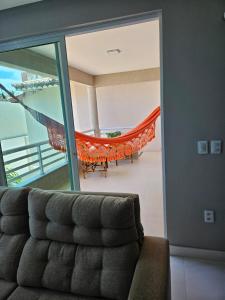 福塔莱萨ARCO IRIS KITNETS的带沙发和吊床的客厅