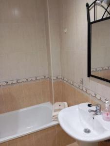 卢安科El rinconín de Luanco的浴室配有盥洗盆和浴缸。