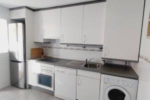 曼萨纳雷斯-埃尔雷亚尔Manzanares Getaway的厨房配有白色橱柜、水槽和洗碗机。