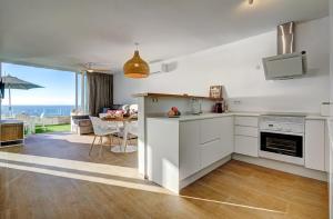 卡亚俄萨尔瓦赫Terrace on the sea的一间厨房,配有白色的橱柜,享有海景