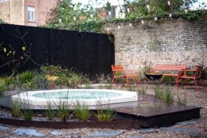 布鲁日B'Guest Sleep & Retreat的花园内的热水浴池,配有桌椅