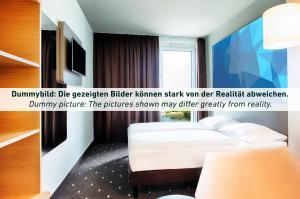 爱尔福特B&B Hotel Erfurt City-West的酒店客房设有白色的床和窗户。