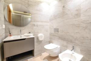 丹吉尔Luxury Apartments的一间带卫生间、水槽和镜子的浴室