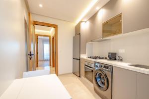 丹吉尔Luxury Apartments的厨房配有洗衣机和水槽