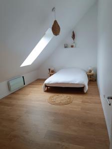 CappyGîte chez Julie et Franck的白色卧室设有床和天窗