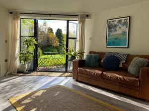 水上伯顿Halford House - Adults Only的客厅设有棕色的沙发和大窗户