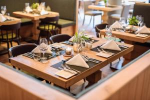 海利根布卢特大格洛克纳山国家公园酒店的餐厅里一张带餐巾和玻璃杯的木桌