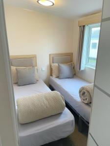 布莱克浦3 bedroom luxury caravan haven, marton mere的客房设有两张床和窗户。