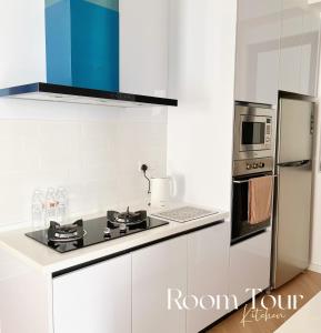 乔治市The Beacon Executive @Penang Georgetown的白色的厨房配有炉灶和冰箱。