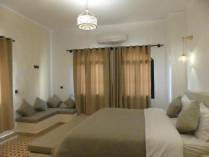 梅尔祖卡Riad La Luna的一间卧室配有一张床和一张沙发