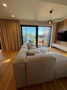 伏尔塔瓦河畔利普诺Molo Lipno apartmán B232的客厅设有一张大沙发,配有大窗户