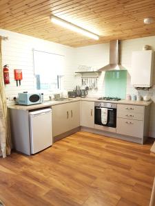 卡尔达夫Crag Na Cor Log Cabin的厨房配有白色橱柜和炉灶烤箱。
