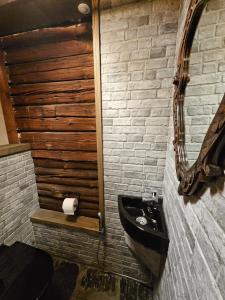 Järvenrantamökki poreammeella的浴室设有黑色水槽和镜子