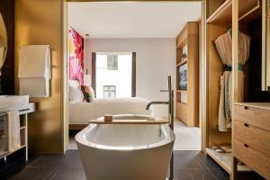 伦敦The BoTree - Preferred Hotels and Resorts的带浴缸的浴室和1间带1张床的卧室