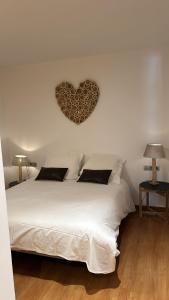 奥尔迪诺Appartement au coeur d'Ordino的卧室配有白色床,墙上有心