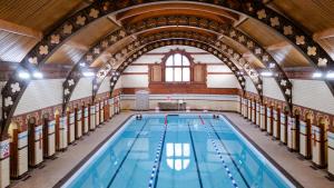 伯明翰阿斯顿会议中心酒店的一座带拱形天花板的建筑中的游泳池