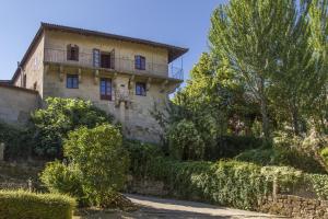 阿拉力兹Casa Rural Torre Lombarda的一座古老的石头房子,位于山上,设有阳台