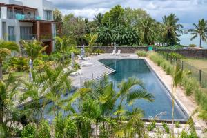 潘托皮芒Prestigious waterfront apartment with huge pool!的一座别墅前方的棕榈树游泳池