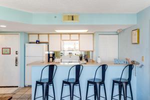 基韦斯特Sunrise Suites - Saint Kitts 412的厨房配有蓝色的柜台和四把椅子