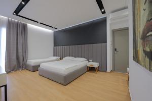 伏罗拉Sea & Sand Hotel的一间卧室设有两张床和大屏幕